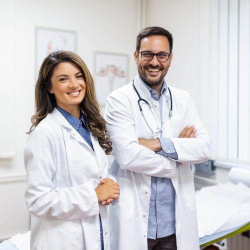 portrait-smiling-young-doctors-standing-together-portrait-medical-staff-inside-modern-hospital-smiling-camera